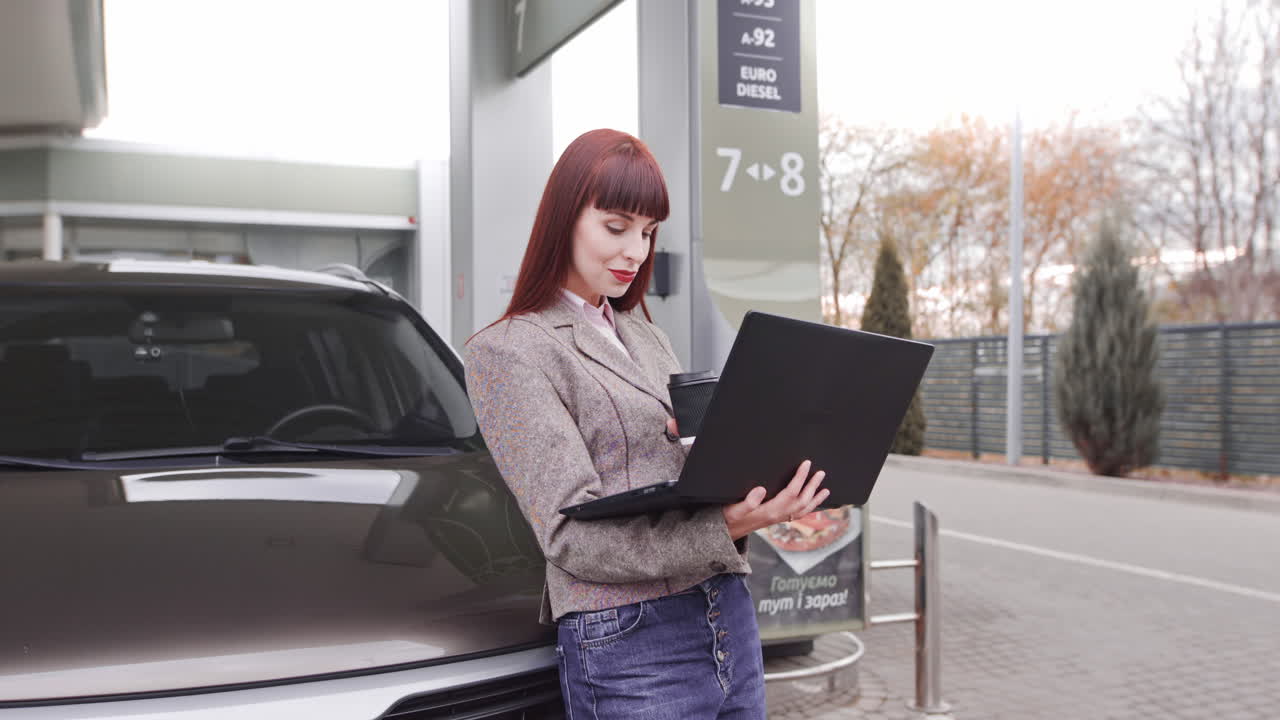 Businesswoman working on laptop at a gas station