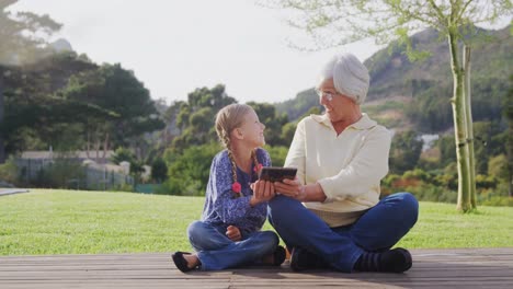 Happy-grandmother-and-little-girl-sitting-and-using-tablet-4K-4k