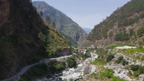 Drone-Shot-of-a-small-road-and-river-in-Himachal-Pradesh-near-Manali,-Kasol-1