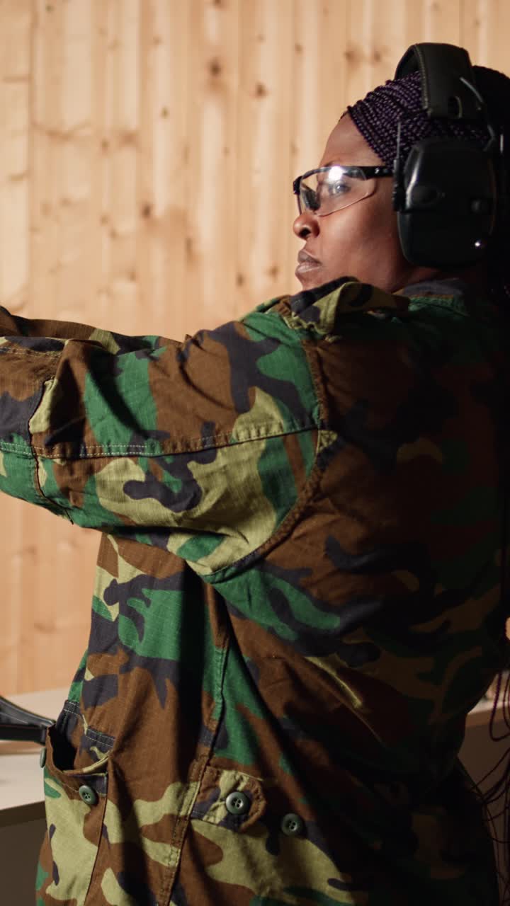 Vertical video Portrait of woman in firing range preparing for mission, shooting pistol