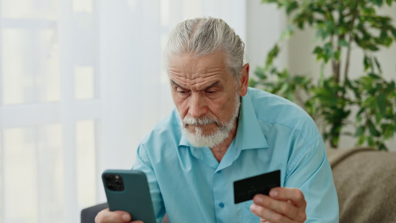 Uomo anziano che usa smartphone e carta di credito per il pagamento online