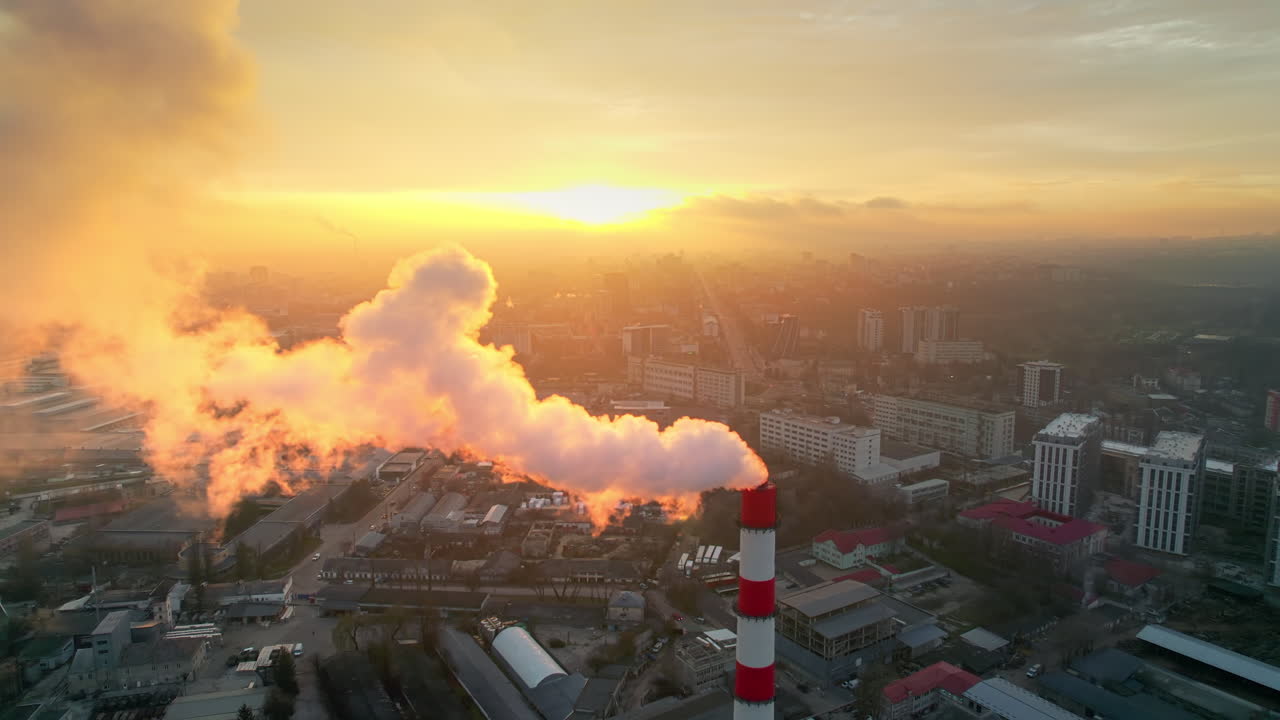 Aerial drone view of thermal power plant in Chisinau at sunrise, Moldova. View of pipe with felling steam, cityscape