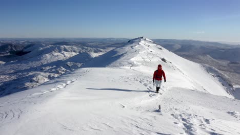 Tired-female-alpinist-reaching-top-of-snowy-peak