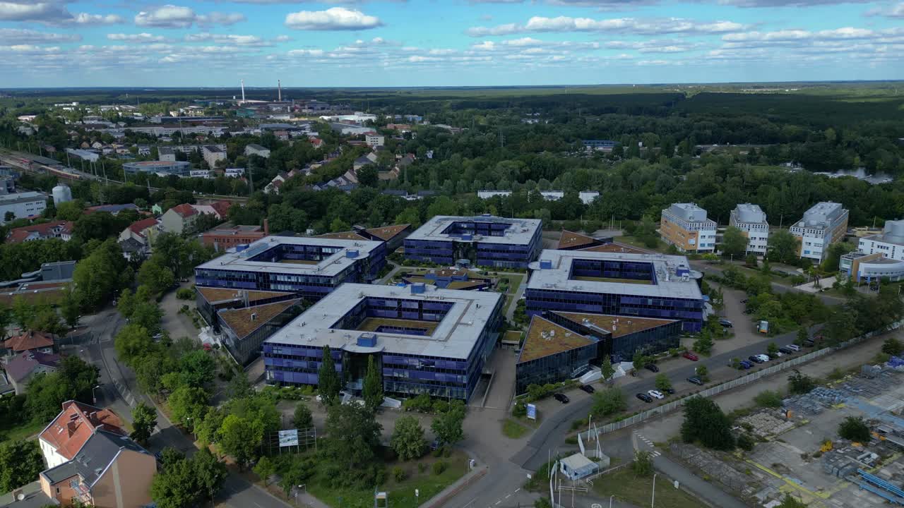 Hennigsdorf, Germany, showcasing residential areas, railway infrastructure and commercial buildings. Dramatic aerial view flight ascending drone