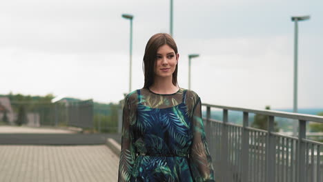 Attractive-lady-in-dress-with-pattern-walks-along-bridge