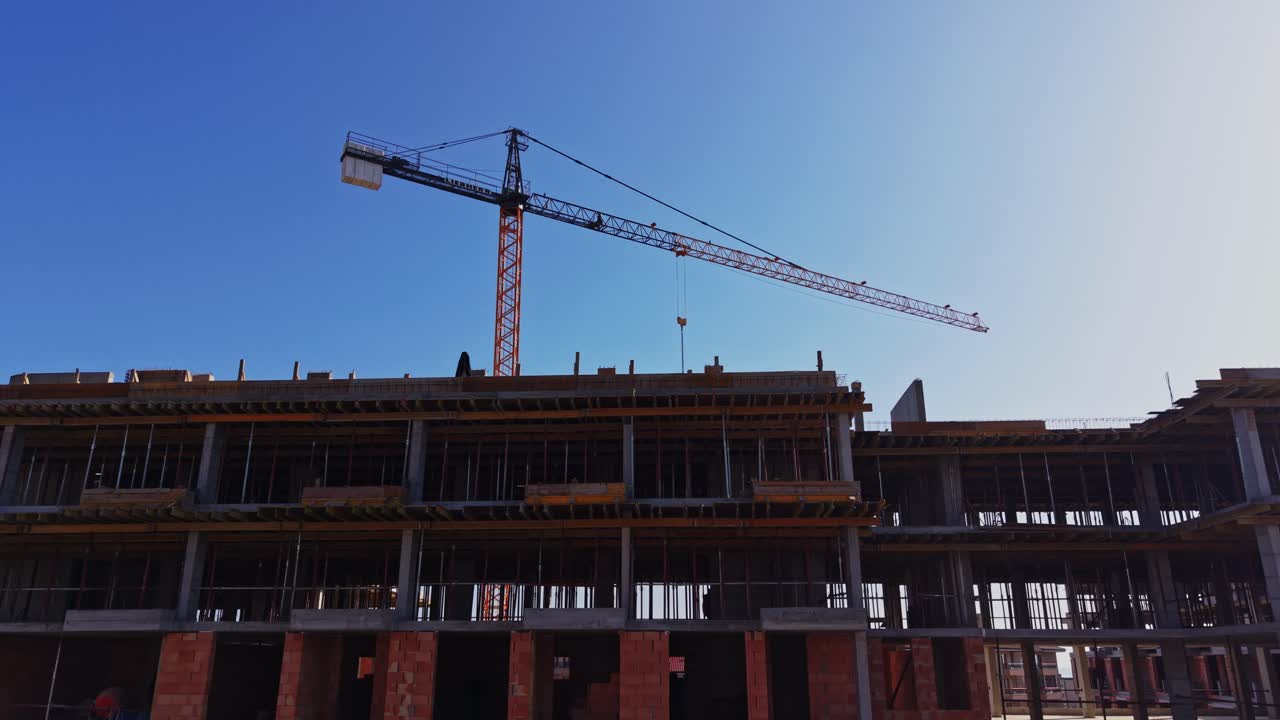 Construction Site with Tower Crane and Workers Against Blue Sky
