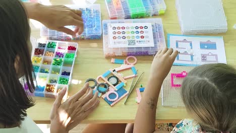 mother and daughter beading together