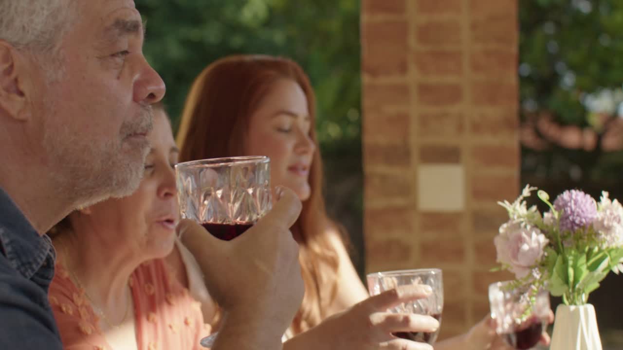 Friends Enjoying Wine and Laughter at an Outdoor Gathering