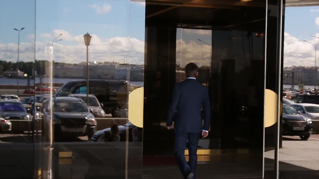 Businessman walking out of a building in a city