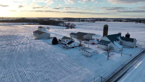 american family farm in white winter snow at sunrise