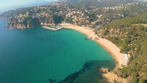 Fascinantes-Vistas-Aéreas-De-Lloret-De-Mar-Y-El-Paraíso-Apartado-De-Cala-Canyelles,-Enclavado-En-Medio-De-La-Belleza-Escarpada-De-La-Costa-Brava