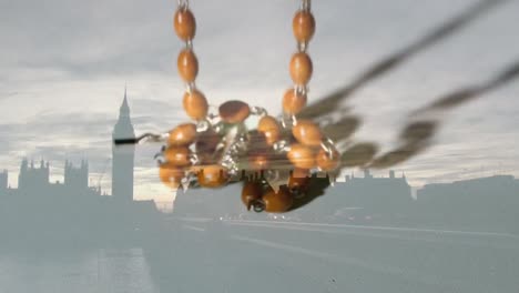 animation of cross and rosary falling over cityscape