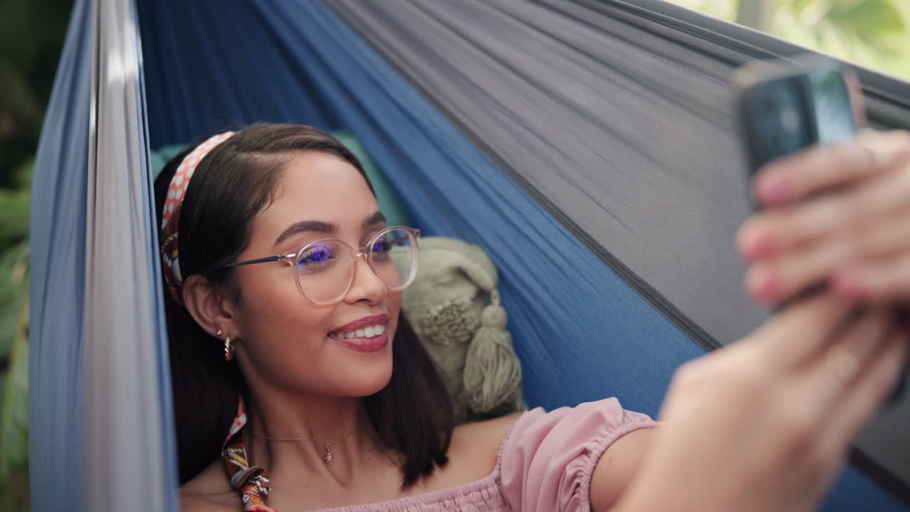 Woman taking a selfie in a hammock
