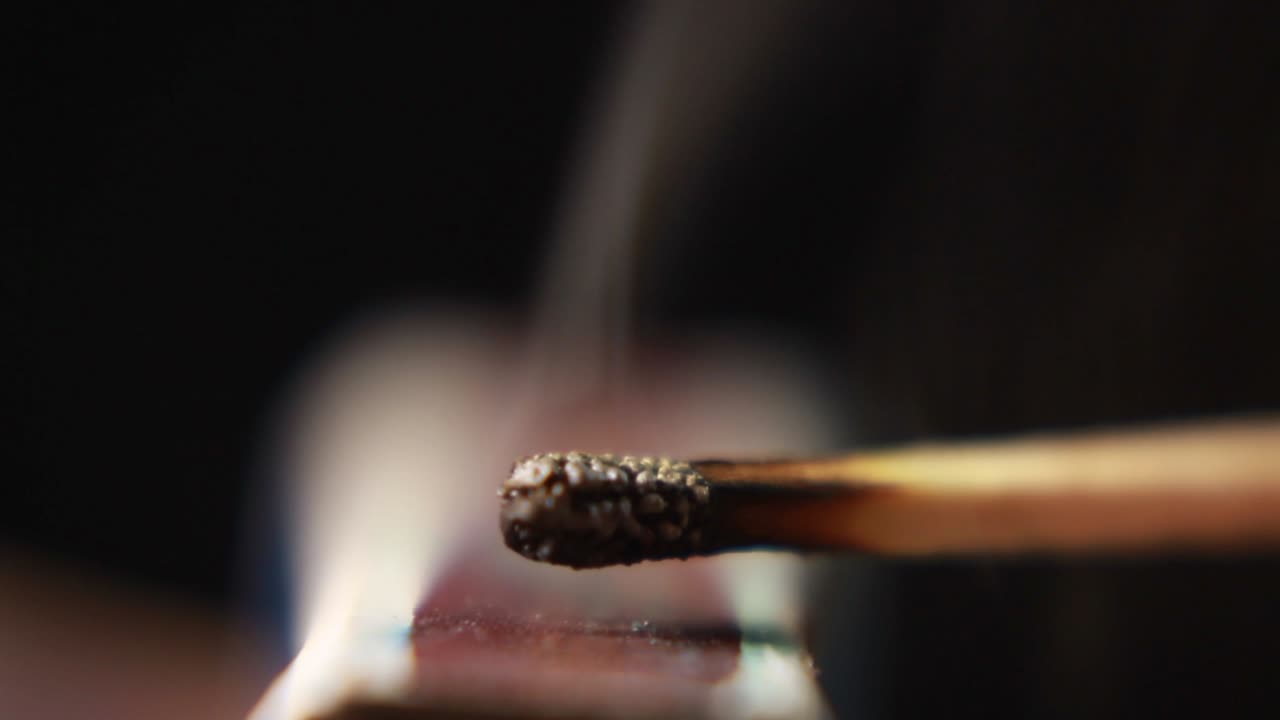 encender un fósforo de una caja de fósforos y apagarlo