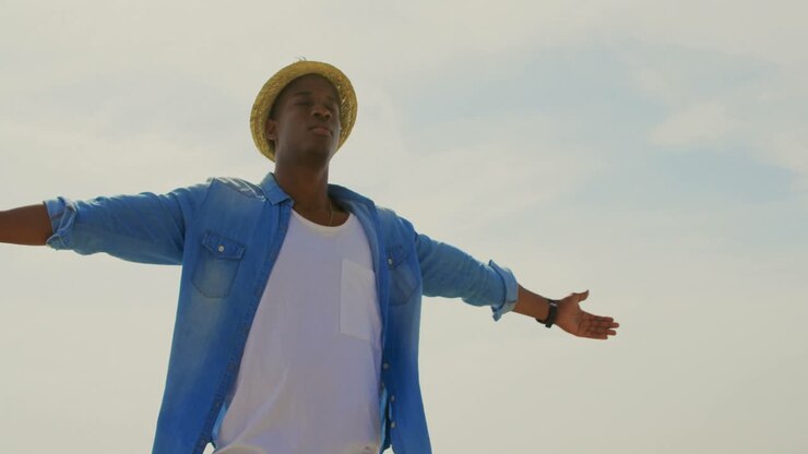 Uomo afroamericano che gira con le braccia distese in spiaggia 4k