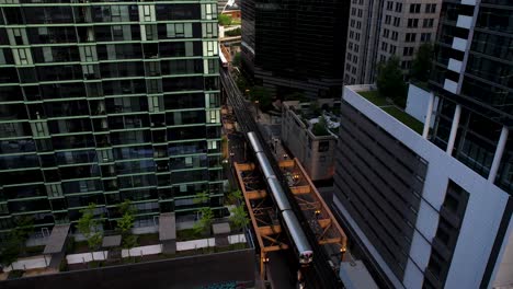 cityscape of chicago l trains passing by luxury apartments in city center downtown