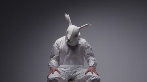 person in rabbit mask and hazmat suit