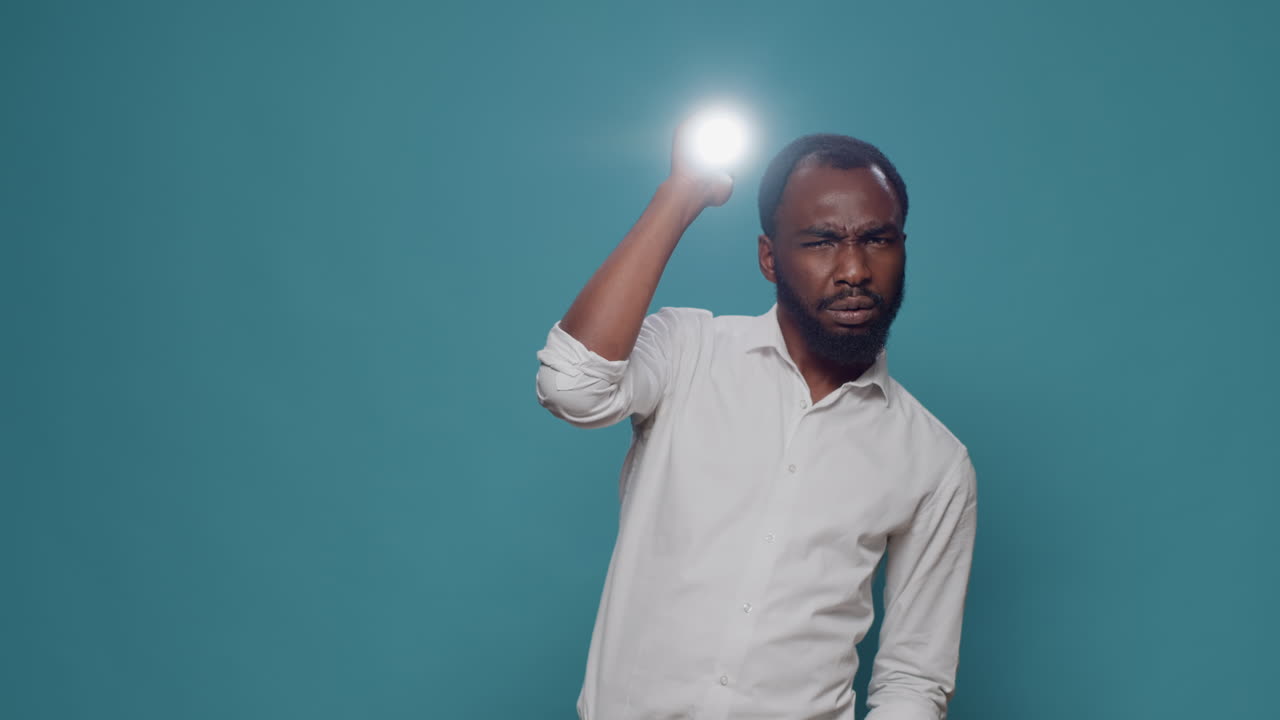 Man holding a flashlight indoors