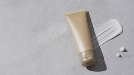 video of beauty product tube and cream smudge with copy space on white background