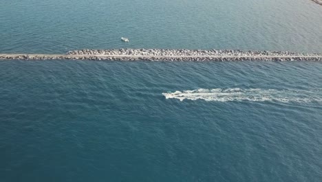 4k aerial drone footage of fishing boat leaving harbor going to the ocean in palm beach florida