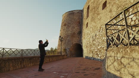 elderly man tourist observes a historic building defensive castle in calabria