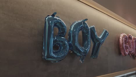 blue helium balloon letters forming word boy during gender reveal party, indoor