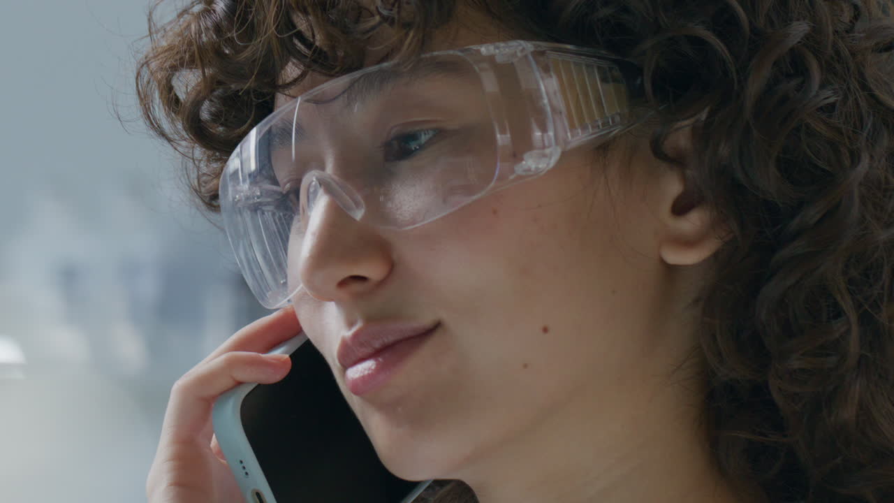Kvinnelig forsker snakker i telefonen på laboratorium.