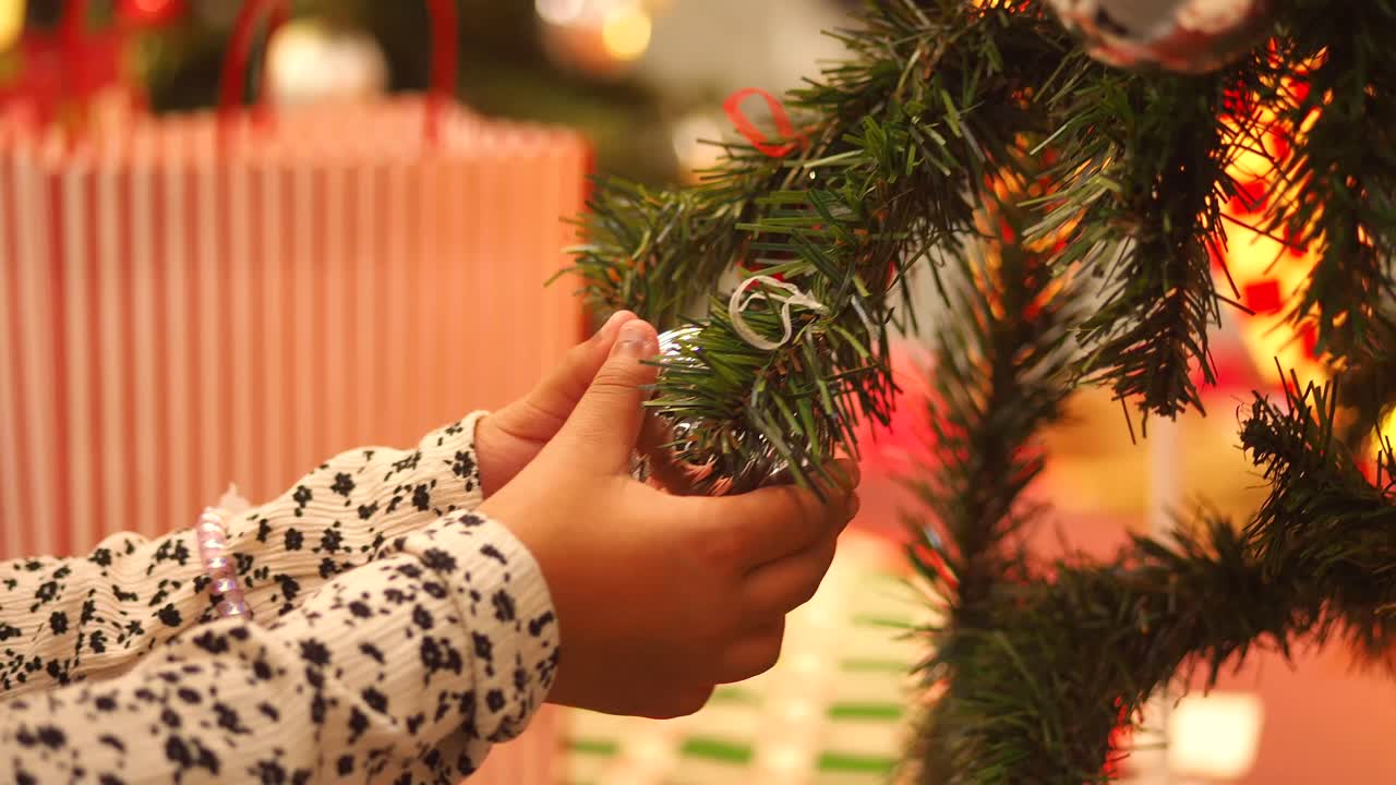 Child decorating Christmas tree with ornaments