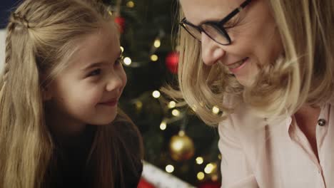 Video-of-happy-grandmother-and-granddaughter-packing-Christmas-presents-together