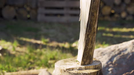 Close-up-view-of-caucasian-man-chopping-firewood-with-an-ax-outside-a-country-house