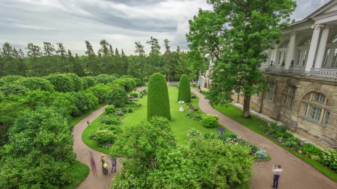 Antike Galerie mit Skulpturen und Garten im Katharinenpark Zeitraffer, St. Petersburg. Blumenarrangements, Bäume, Büsche. Bewölkter Sommertag