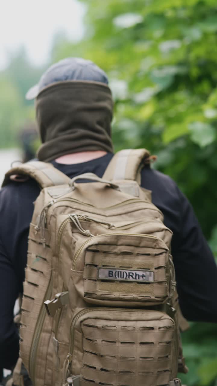 Person with a tactical backpack in a forest