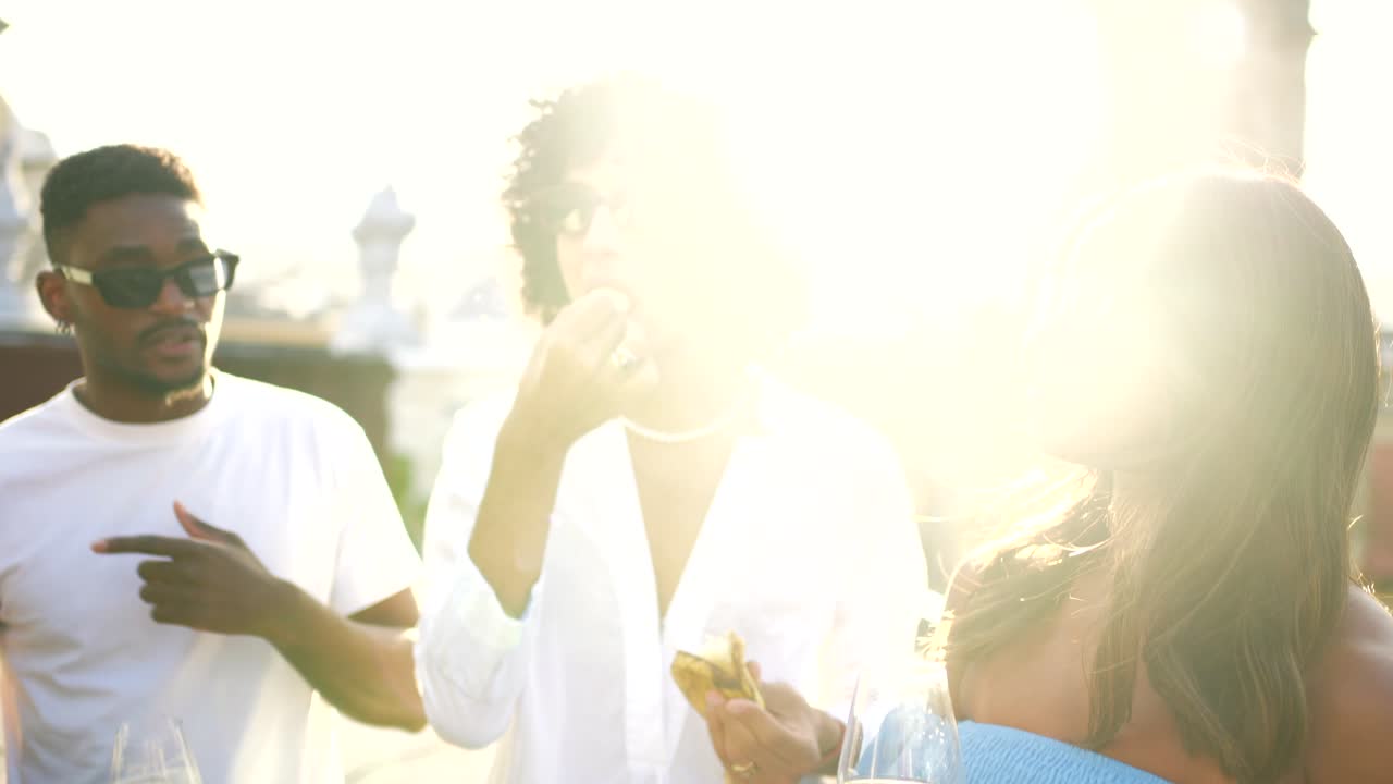 Friends enjoying a rooftop party with drinks at sunset