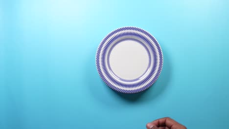 a white plate with a blue rim and a geometric pattern on a blue background.