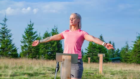 a woman with her arms spread standing on an energy point over a hill