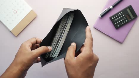 persona que pone dinero en efectivo en un sobre