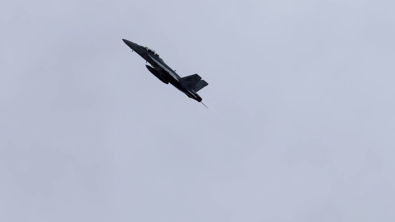 A jet executes dynamic aerial maneuvers against a cloudy sky at the Avalon Airshow in Geelong, showcasing precision and agility
