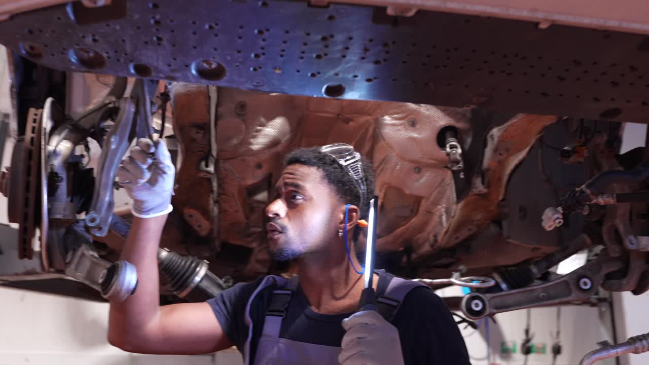 Auto Mechanic Working Underneath Car