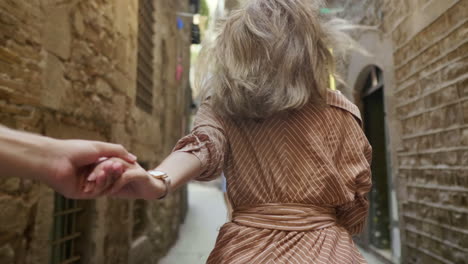 woman with man hand looking at camera outdoor