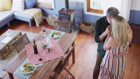 Happy-caucasian-mature-couple-dancing-in-the-sunny-living-room