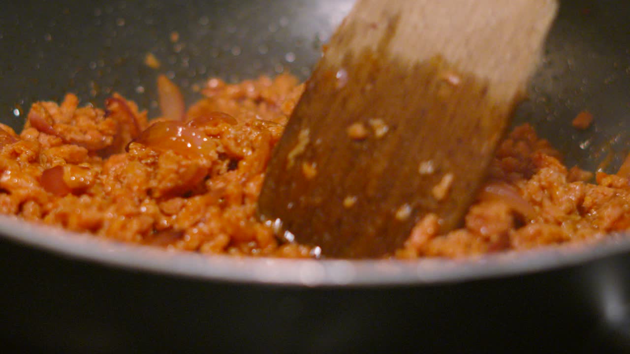Plant Based Meatless Mince with Red Onions Being Cooked in Hot Pan with Wooden Spatula