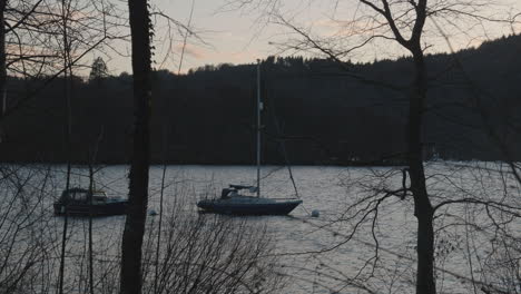 Velero-Se-Balancea-Suavemente-Sobre-Un-Lago-En-El-Distrito-De-Los-Lagos-Del-Reino-Unido,-Inglaterra