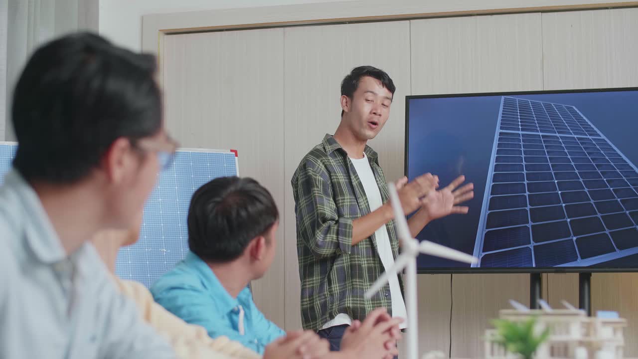 아시아 남성 엔지니어가 사무실에서 태양전지 작업에 대해 성공적으로 발표하면서 관객들은 박수를 치며 인상적 느낌을 받았습니다.