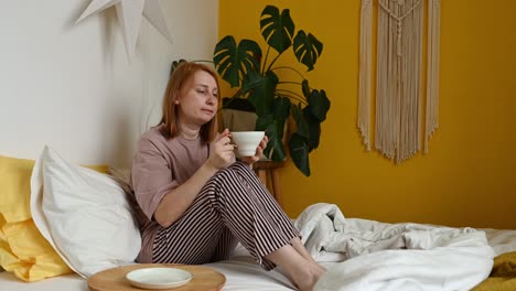 woman drinking coffee in bedroom