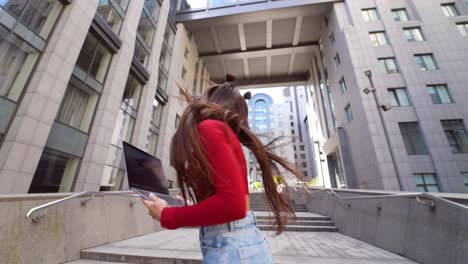 young woman working on laptop in city