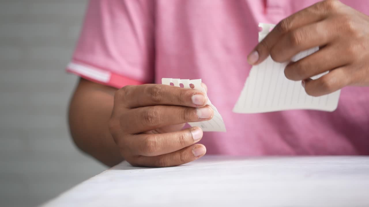 persona rasgando un pedazo de papel