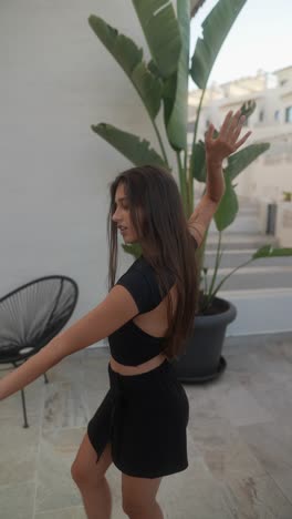 mujer joven con ropa negra, bailando al aire libre