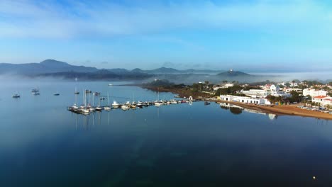 Marina-in-Fornells-Bay,-Menorca-with-glassy-waters-on-summers-morning