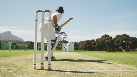 jugador de cricket que pierde la pelota en un campo