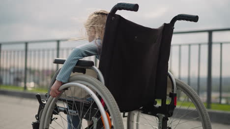 Girl-spins-wheels-of-medical-equipment-to-move-on-viewpoint